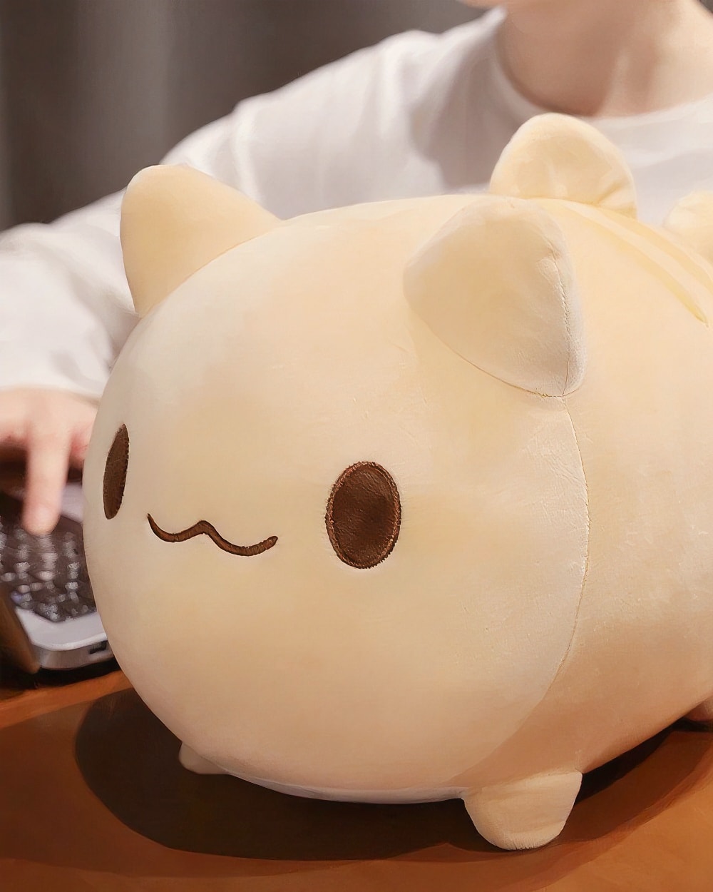 Close-up of a beige round neko plushie with brown eyes and ears.