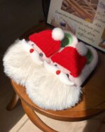 Close-up of santa claus home slippers decorated with a hat and earmuffs, showcasing a kawaii winter design.