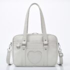 Light gray japanese schoolbag with handles and shoulder strap, featuring a heart shaped pocket.