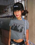 Model wearing a gray retro grunge t-shirt featuring a band graphic.