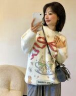 Woman wearing a kawaii rabbit sweater with floral and rabbit motifs.