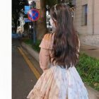 Soft girl dress featuring floral details and ruffles, worn by a person.