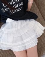 White coquette ballet skirt layered over a black top.