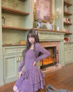 Purple lace gothic aesthetic dress worn by a model in a vintage setting.