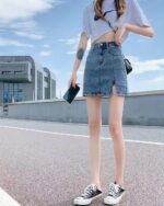 High waist denim skirt in y2k aesthetic style, featuring a side slit and distressed detailing.