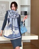 Vegan cashmere scarf draped over a woman's dress, featuring a blue floral pattern.