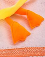 Close-up of a Waddles and Puddles goose plush toy, featuring orange wings and a yellow body.