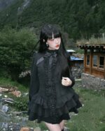 Black laced short dress - Gothic Aesthetic, a ruffled, layered dress with lace details worn by a model outdoors.
