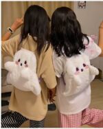 Ghost plushie backpack shown being carried by two people, white and fluffy.