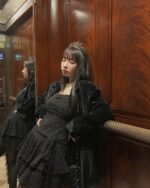 Model wearing a black lace spring dress with gothic aesthetic details and a crown.