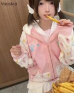 A model wearing a pink harajuku hoodie with paw print details and a cute design.