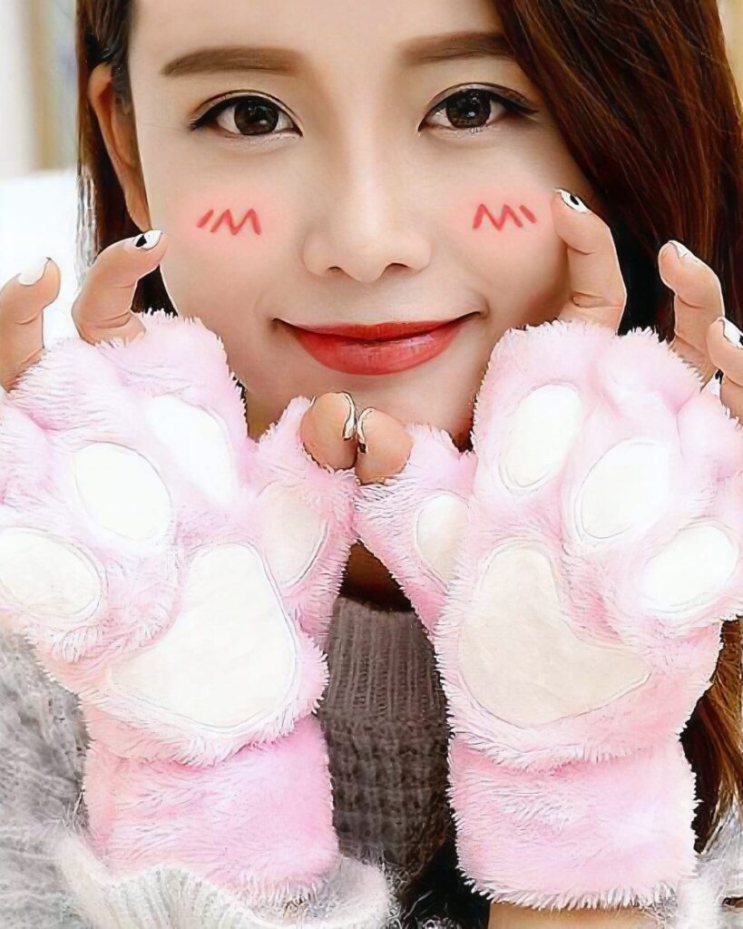 Pink neko paw gloves being held by a woman, Winter Collection.