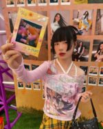 Model wearing a pink cutecore top with floral details and stars.