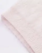 Close-up of a soft, white neko sweater with ribbed texture.