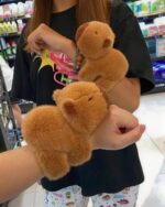 Two brown capybara plushies held together in a shopping mall.