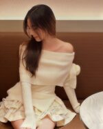 One shoulder bow knitted set: cream-colored knit top and ruffled skirt.