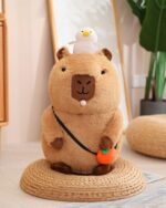 Capybara plushie with a duck and carrot accessory. Soft, cuddly toy.