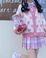 Pink kawaii knitted sweater with heart details, a cute fashion item.
