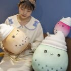 Two bubble tea plushies, one milk tea and one fruit tea, held by a person.