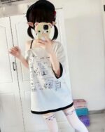 Model wearing a harajuku kawaii t-shirt with cute character prints and white knee-high socks.