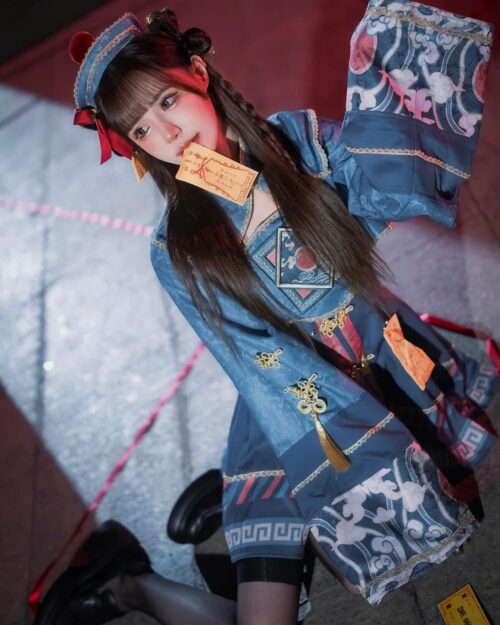 Model wearing a blue and floral jiangshi lolita costume with traditional details and accessories.