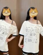 Two people wearing a harajuku kawaii t-shirt featuring cat illustrations and a pink trim.