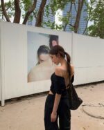 Woman wearing a black korean off-shoulder top with a casual, coquette aesthetic style.