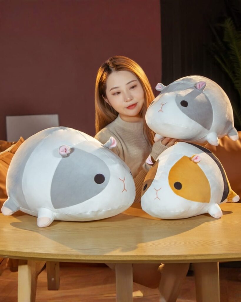 Kawaii guinea pig plushie, grey and brown, displayed on a wooden table.