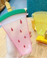 Close-up of a pink kawaii fruit bottle shaped like a watermelon, featuring a drinking straw and anti-drop design.