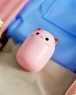 Pink kawaii cat humidifier aromatherapy machine on a textured blanket.