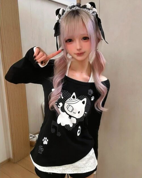 Patched Neko off-shoulder t-shirt featuring a cat design with patches and a layered outfit.