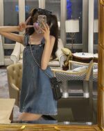 A light blue kawaii denim dress with straps, worn by a person in a hotel setting.