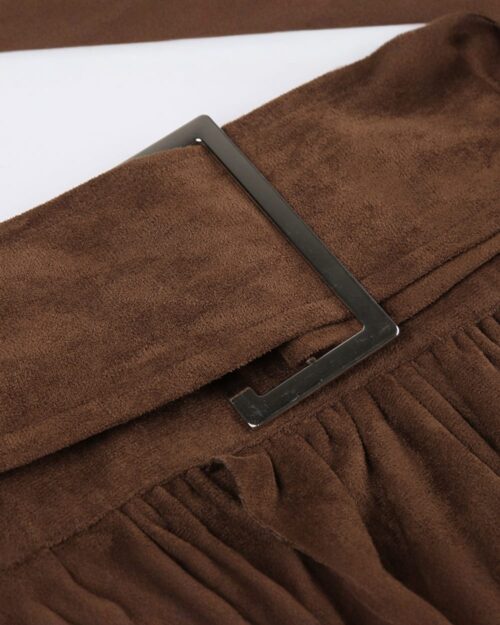 Close-up of an aesthetic vintage skirt with brown suede and a black buckle.