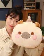 Round animal hand warmer plushie featuring a pig design with pink details and a small hat.