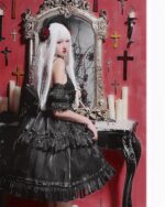 Model wearing a black gothic lolita dress set with ruffles, posing with a mirror and candles.