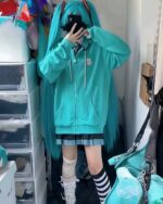 Turquoise harajuku hoodie worn by a model, featuring a zipper and a bear graphic.