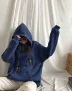 Blue ethno-chic hoodie with embroidered details, worn by a person.