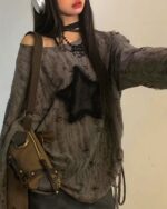 Gray grunge star top with ripped details. This off-shoulder grunge star top features a distressed texture and star applique.