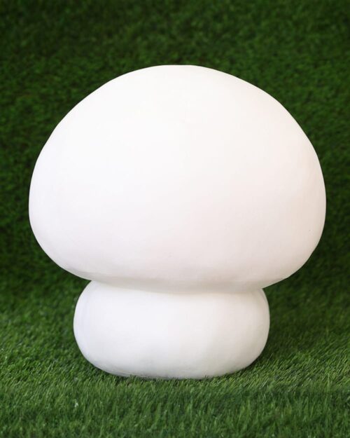 White giant mushroom plushie resting on green artificial turf.