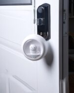 Kawaii cat lamp attached to a door, body-activated night light emitting a soft glow.