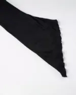 Black gothic aesthetic dress, close-up of ruffled fabric detail.