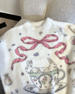 Kawaii rabbit sweater featuring a floral design with a pink bow and rabbit details.