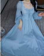 Light blue long sleeve fairycore dress with lace details and flowing skirt.