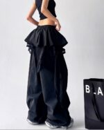 Black y2k cargo pants with ruffled detailing and lace trim. High-waisted, wide-leg style.
