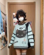 Model wearing a mint neko sweater with a black cat graphic.