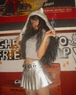 Woman wearing a silver pleated skirt and faux fur hat, coquette aesthetic style.