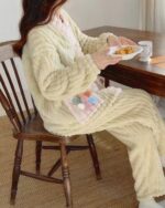 Close-up of thick kawaii plush pajamas featuring a textured design and pom-poms.