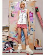 Model wearing a white sleeveless punk hoodie with a grunge aesthetic design, featuring graffiti-style artwork.