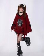 Red loose gothic sweater with spider web detail, worn by a model.