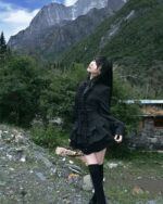 Black laced gothic lolita dress worn outdoors against a mountain backdrop.